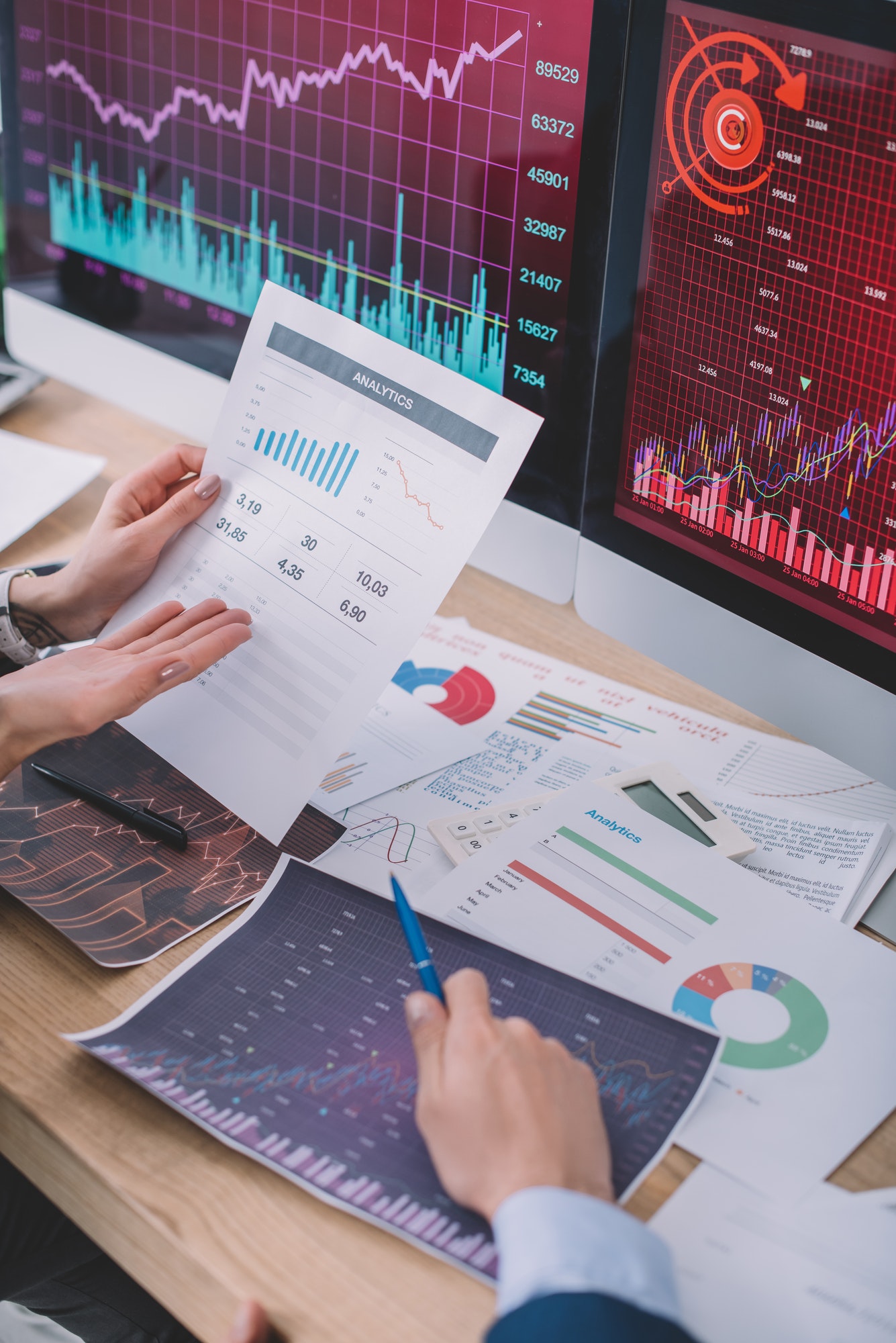Cropped view of data analysts using charts while developing software for computer systems